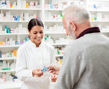 pharmacist helping man with prescription
